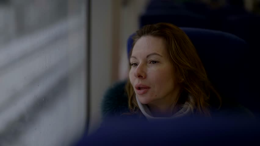 lonely middle-aged woman in train, portrait of pensive lady looking at window, female passenger Royalty-Free Stock Footage #1105901607