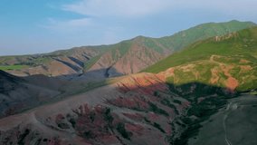 Hills of different colors. Journey through the natural attractions of summer Kyrgyzstan. High quality 4k aeral drone footage witn amazing mountain landscape at sunset