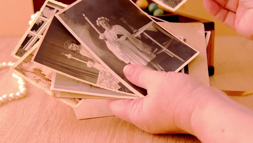 female hands are sorting dear to heart memorabilia in an old wooden box, stack of retro photos, vintage photographs of 1960, concept of family tree, genealogy, childhood memories, home archive Royalty-Free Stock Footage #1105905027