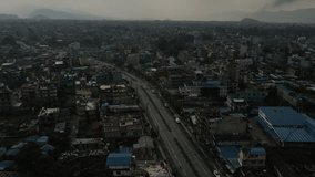 Aerial view of the city of Pokhara in Nepal overlooking a road with moving traffic. Flying a drone through a poor city. 4k footage.
