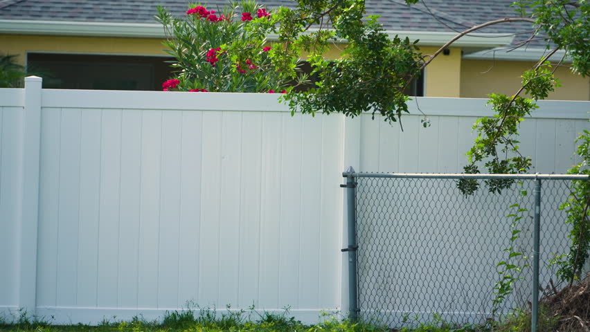 White plastic fence for back yard protection and privacy. Vinyl plank fencing in Florida