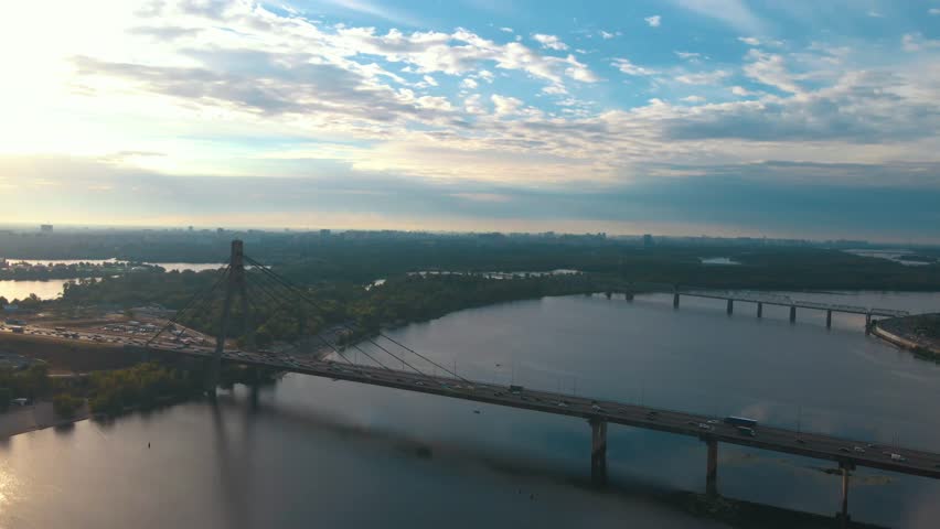 Aerial drone view of road bridge, North bridge over Dnipro river. Sunset in Obolon district, Kyiv, Ukraine