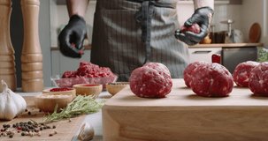 Chef prepares blanks for meatballs from fresh minced meat in a kitchen with subdued lighting, Professional promotional video Advertising. Slow and calm lifestyle, making burger. Cook food