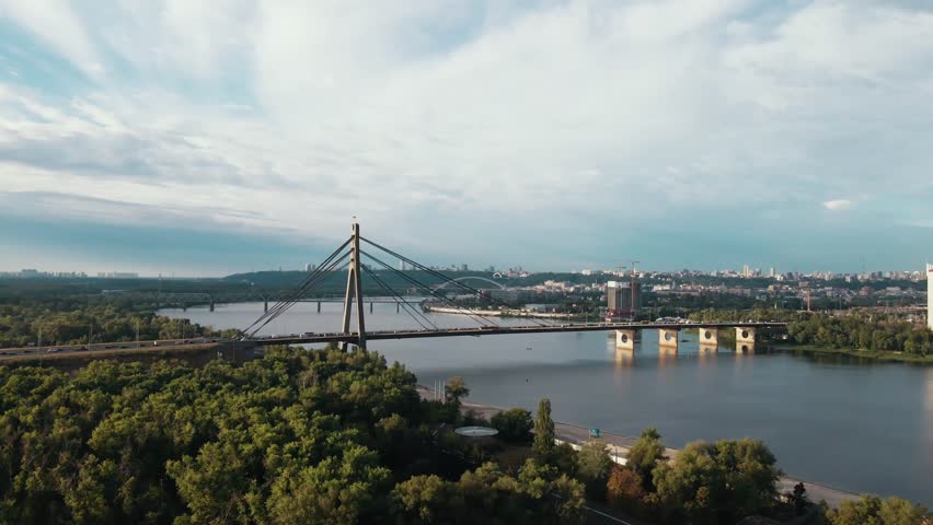 Aerial drone view of road bridge, North bridge over Dnipro river. Sunset in Obolon district, Kyiv, Ukraine