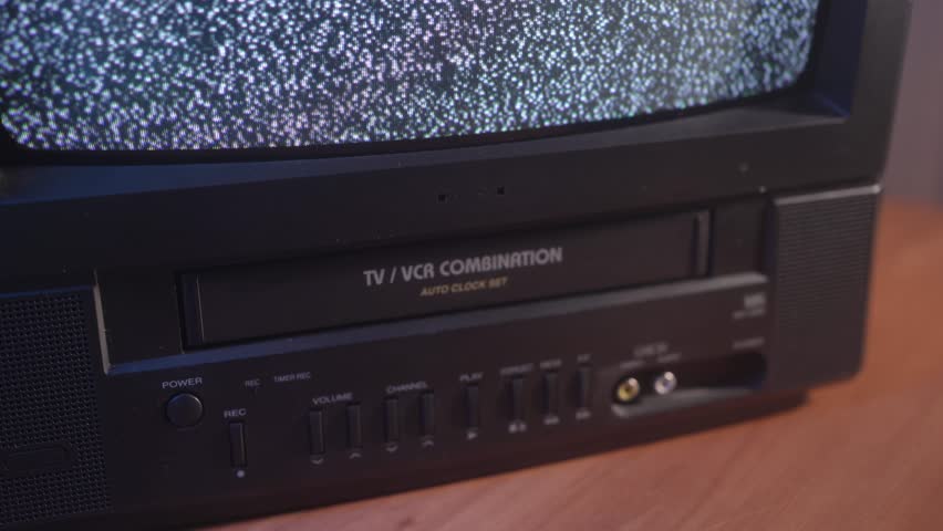 Inserting a VHS tape in a TV VCR to watch an old vintage movie. Royalty-Free Stock Footage #1105915141