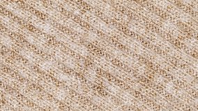 Beige knitted fabric with diagonal seams, rotating, turning, close-up macro, top view, looped video
