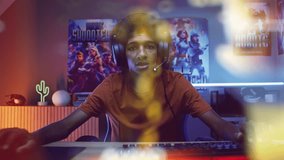 Portrait of teenage gamer in headphones playing shooter on computer at home. View from PC screen perspective with animated online video game. Gaming and cybersport. Futuristic VFX animation. Zoom out.