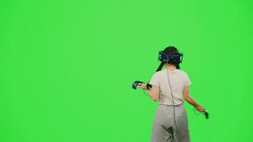 The little girl wearing VR headset dancing in virtual reality. The child dancing on chroma key green screen background in virtual reality. Concept dance in VR headset leisure activity virtual reality