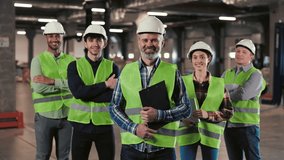 A Group of Warehouse Workers Stands in a Large Distribution Center with their Arms Crossed. Portrait of the Workers. People Looking at the Camera with Smile. Logistic. Distribution - Powered by Shutterstock - Get 15% off with code: PIKWIZARD15