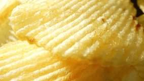 Macro video captures the texture of wavy potato chips with a mesmerizing probe lens. The ridges create a delightful crunch, while the golden color beckons you to indulge in their savory deliciousness.