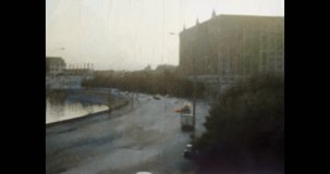City embankment in morning, wide footage. Beautiful calm city street landscape. View of road with moving cars, river water. Archival vintage color film. Archive video. Old retro 1980s Moscow, Russia