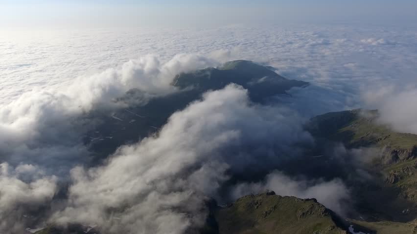 Aerial view of the Alps mountains above the clouds in Europe.