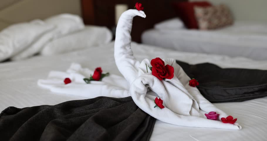 Toallas de cisne en la cama en una habitación de hotel