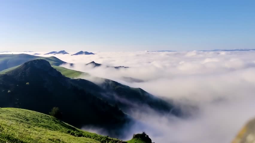 Low clouds flow like a river in alpine mountains valley in beautiful autumn nature landscape Time lapse