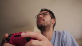 Bearded man playing videogames with red controller