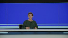 BLUE SCREEN CHROMA KEY Caucasian female anchorwoman reporting on a story in live news studio. Television newsroom channel with professional anchor presenter