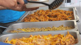 Huge dishes with rice or pilaf on the counter of the street food festival