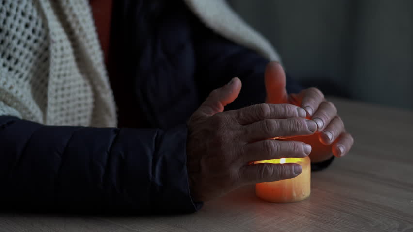 Senior man without electricity at home with candle, hands close-up. Shutdown of heating and electricity, power outage, blackout, load shedding or energy crisis. Royalty-Free Stock Footage #1105958433