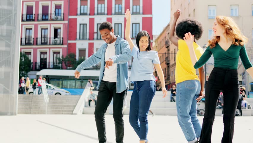 Multiethnic friends dancing in the street on a sunny day