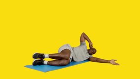 African man doing mermaid oblique crunches in a mat