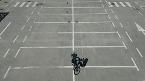 Female cyclist is riding a road bicycle on a parking lot. Female cyclist wearing a cycling kit and a helmet.Sport motivation video