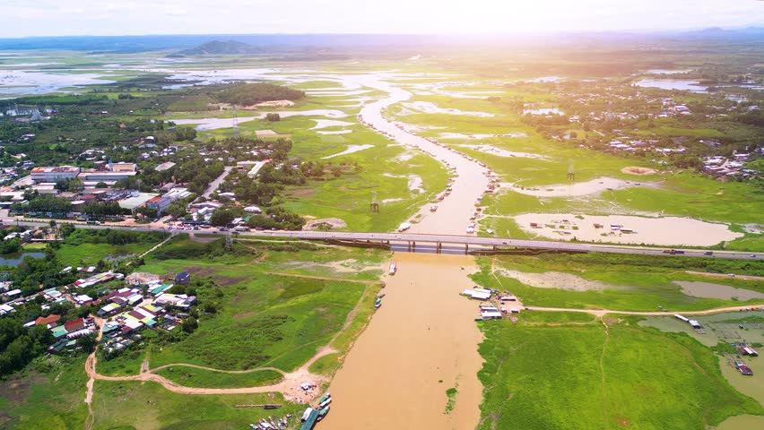 Aerial view of National Route 20 in Dong Nai province, group of floating house on La Nga river, Vietnam with hilly landscape and sparse population around the roads. Travel and landscape concept. Royalty-Free Stock Footage #1105962171