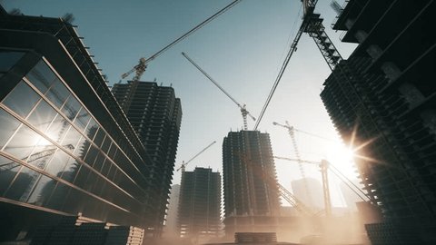 Construction site at sunrise. Cranes working on construction site on sunset. Apartment buildings and crane at construction site Video de stock