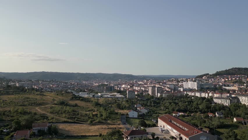 Blue sky flyover: Low mountains seen outside city of Ourense, Spain