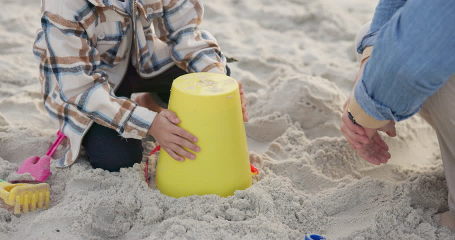 Hands, family and child with sand castle at beach for holiday, vacation or bonding fun. Man playing with girl and bucket toys for quality time, travel adventure and building for development at sea