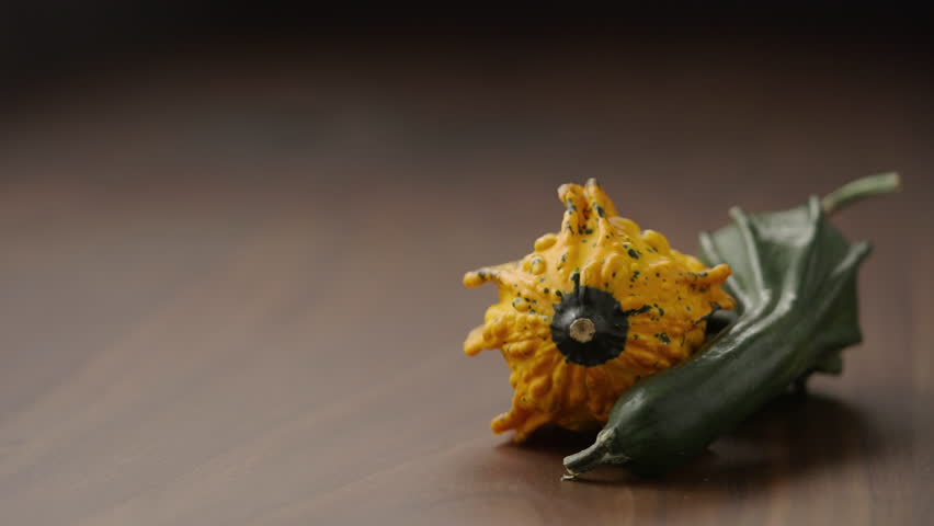 Slow motion man put thanhksgiving card next to decorative pumpkins on wood table