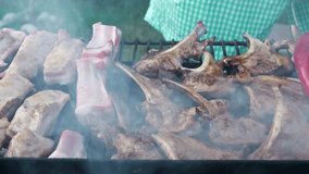 Grill lamb ribs on a hot summer day. Prepares delicious meat in nature. Cooking meat on an open fire. Picnic menu. Video about food.