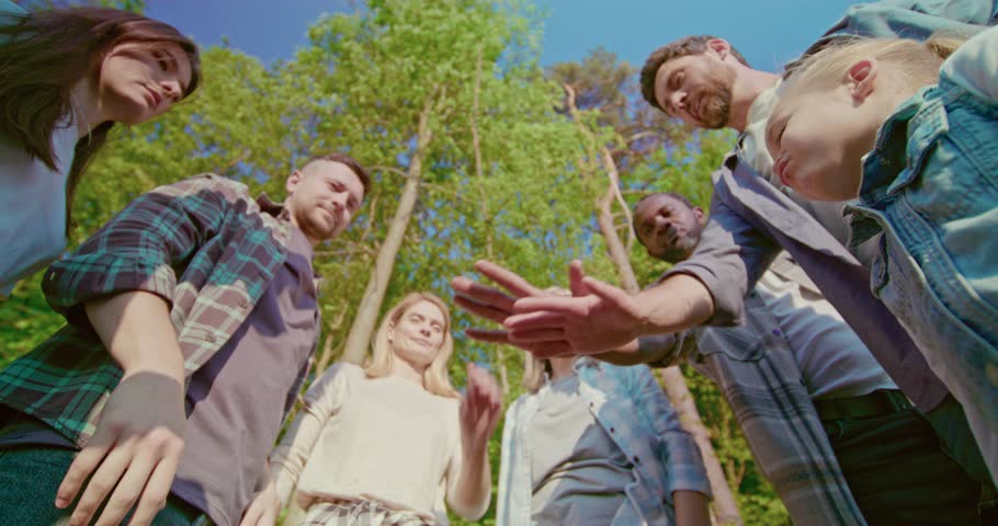Young beautiful group of eco activists standing shaking hands after successful work outdoors. Diverse team of volunteers, men and women, stand in circle and shake hands. Group of like-minded people. Royalty-Free Stock Footage #1105971825