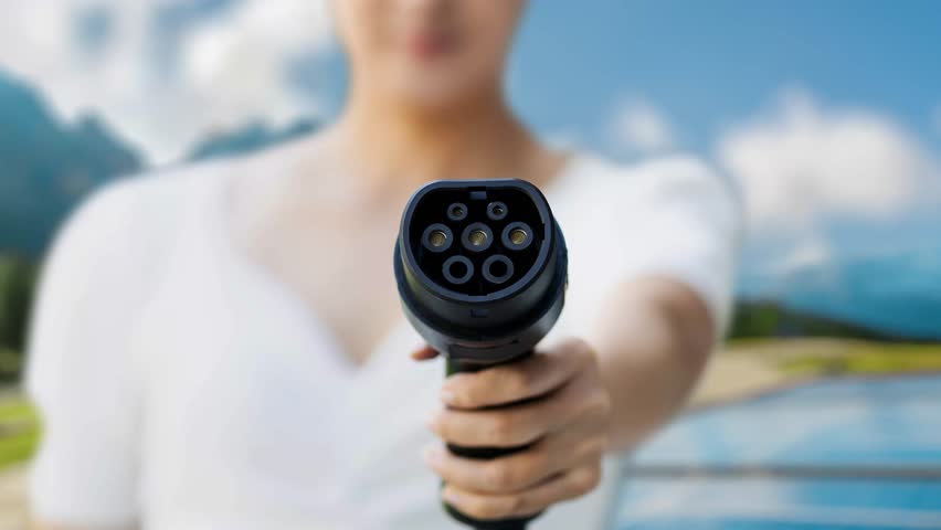 Focus EV charger pointing in front of camera display futuristic eco-friendly energy infrastructure pictogram icon hologram. EV car charger using renewable energy for sustainable power. Peruse - Powered by Shutterstock - Get 15% off with code: PIKWIZARD15