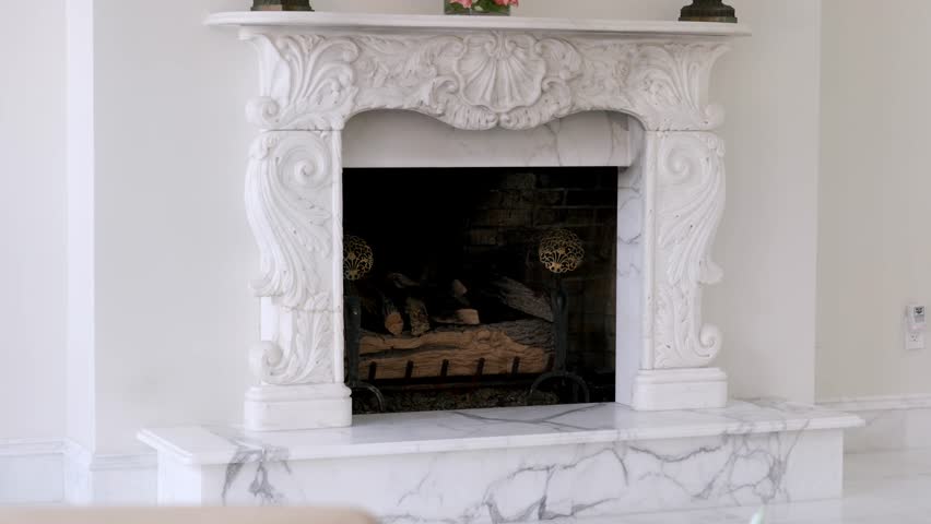Luxury fireplace made with white marble and elegant ornament mantelpiece in modern mansion. Cozy stylish place for family relaxation at home Royalty-Free Stock Footage #1105977143