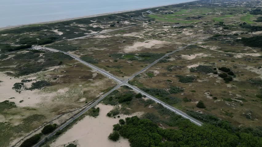 Beautiful crossroads in dunes near the seaside in national park. Nature reserve view from drone.