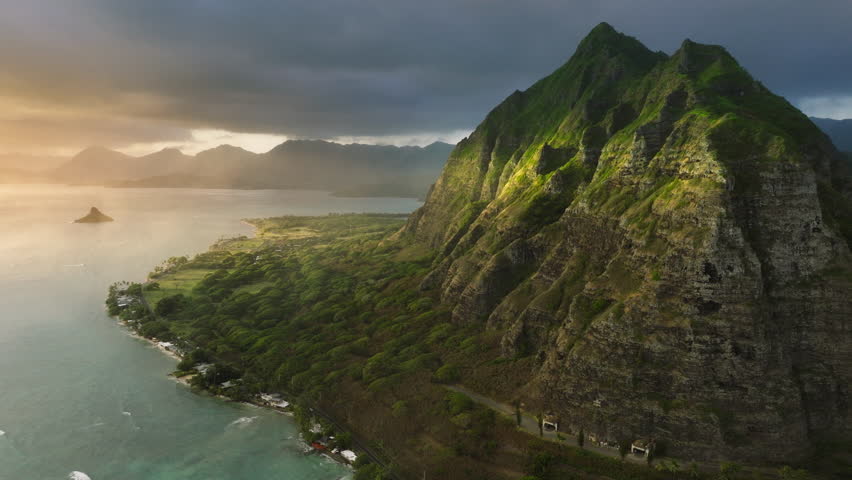 Cinematic Hawaii nature landscapes at golden sunrise. Scenic Oahu coast with beautiful ridges of volcanic mountains. Incredible scenery of green and weird-shaped peaks over ocean coast.Kualoa Ranch 4K Royalty-Free Stock Footage #1105985287