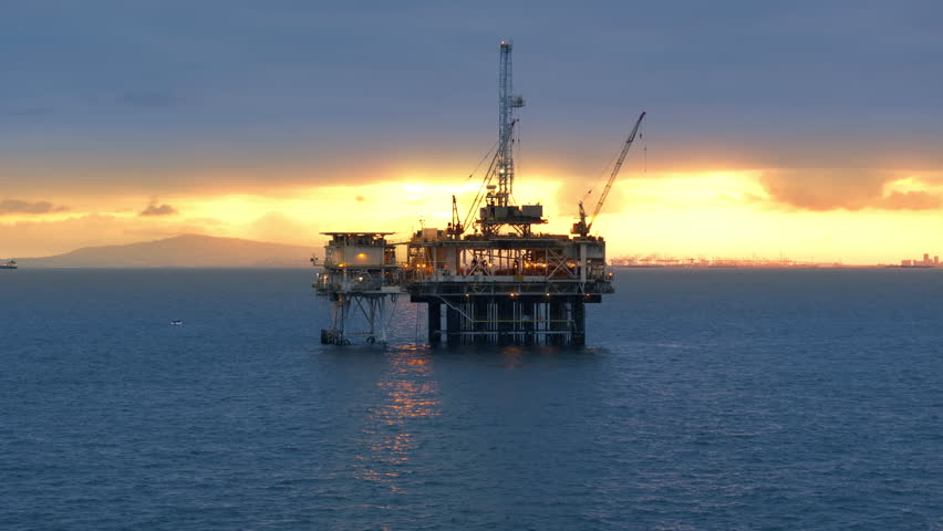 Aerial view of offshore oil drilling rig in the Gulf of Santa Catalina at beautiful sunset. Mining. Profitable gas and oil business industry in California. High quality 4k footage Royalty-Free Stock Footage #1105985291
