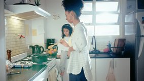 Young African-American mother cooking food on gas stove and speaking with cute little daughter sitting on kitchen countertop. Family life, happy parenthood concepts - Powered by Shutterstock - Get 15% off with code: PIKWIZARD15