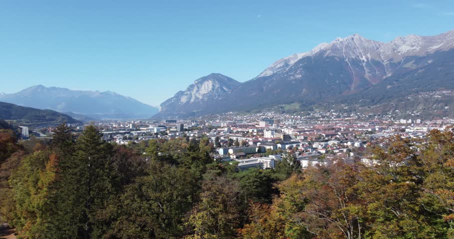 Innsbruck in an aerial view with the alpine valley and the forests on the hills and in the background the mountains with their peaks of this area of ​​Tyrol in Austria