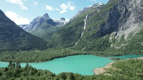 Aerial video of Lake Lovatnet and a waterfall spilling into the lake, in Lodalen Valley, Norway