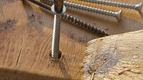 Woodworker screwing a screw in a wood board. 4k macro video footage