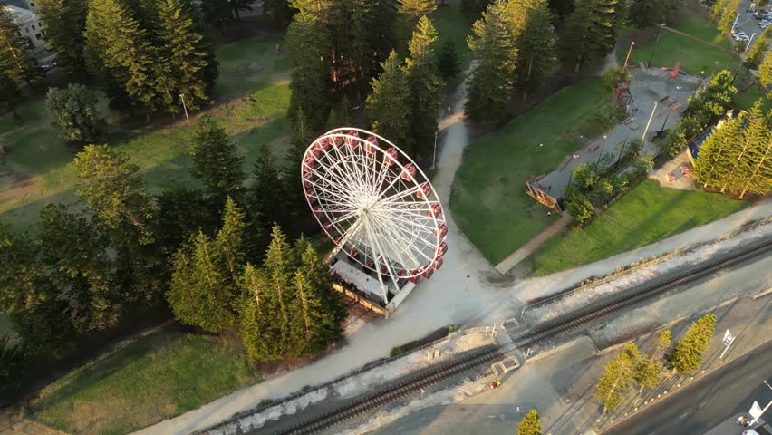 Aerial top down shot of spinning ferris wheel in Esplanade Park during golden hour - Perth Town, Western Australia 