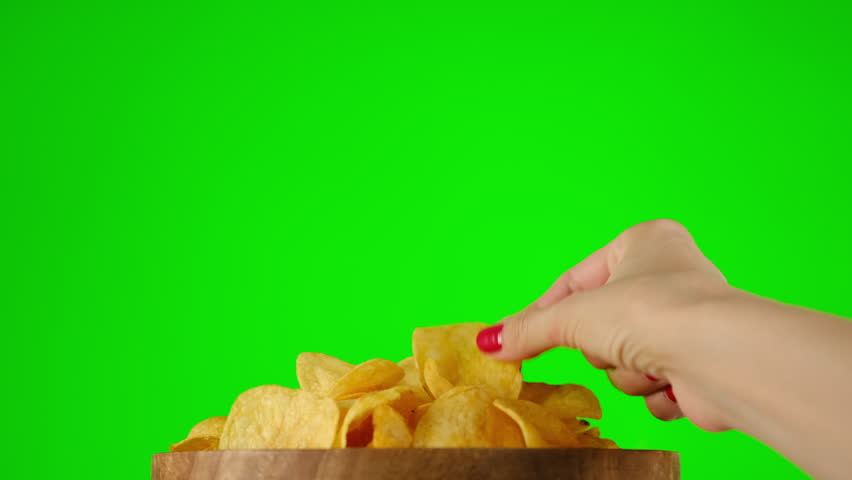 Couple man and woman eating snack potatoes chips on green screen chroma key background