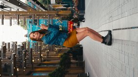 Vertical video portrait of young female vlogger or social influencer travelling through city for social media jumping in street - shot in slow motion