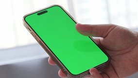 Phone with green chromakey screen in hand of male. High quality video