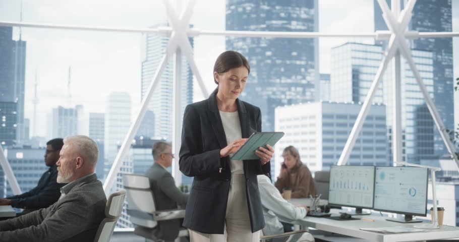 Successful Businesswoman Using Tablet Computer, Standing in Modern Diverse Office in Downtown And Working on Financial, Business and Marketing Projects. Portrait of Beautiful Caucasian Manager. Royalty-Free Stock Footage #1105999149