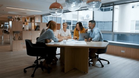 Architectural designers having a team meeting in an office, discussing blueprints and plans for a project. Group of business people contributing their ideas as they collaborate on a design. Video stock