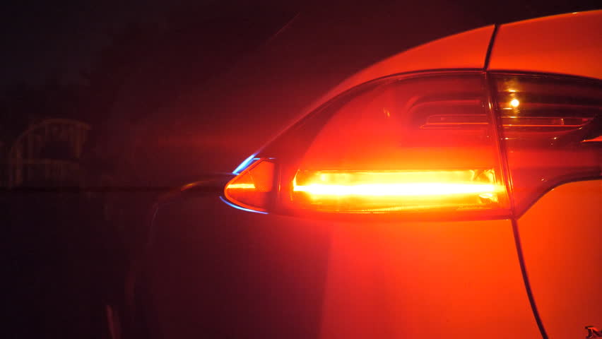 Male hand plugging out a charger from electric car at night time. Man gets out power cord from his auto after charges batteries. Concept of modern technology and ecology friendly transportation
