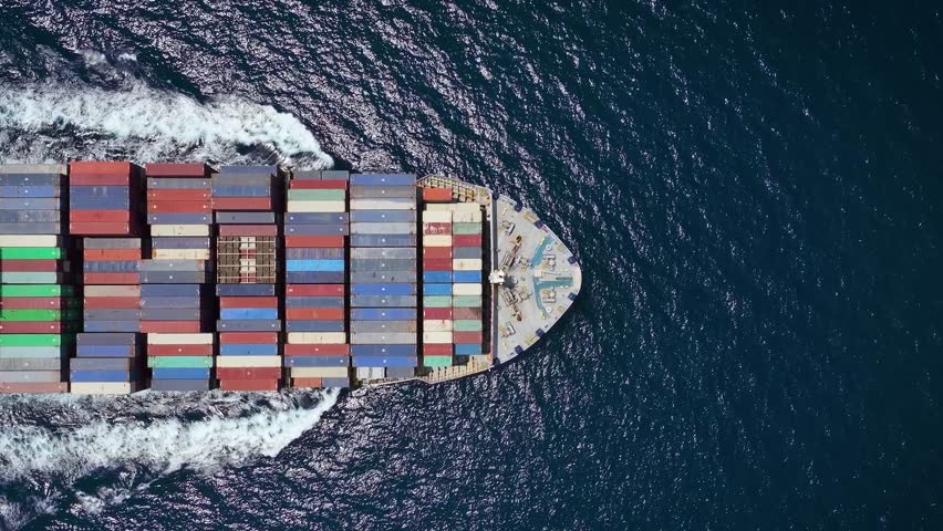 Aerial top down tracking of a large industrial container cargo ship crossing the sea with speed Royalty-Free Stock Footage #1106000885