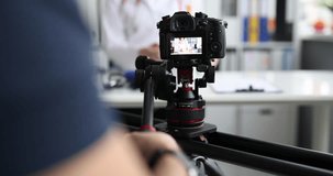 Videographer filming doctor on professional camera closeup 4k movie slow motion